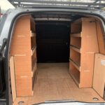 Fully plylined van interior with custom shelving for optimized storage and organization.