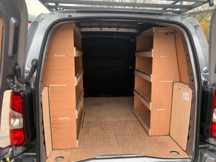 Fully plylined van interior with custom shelving for optimized storage and organization.